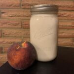 Homemade yogurt in a mason jar with a peach