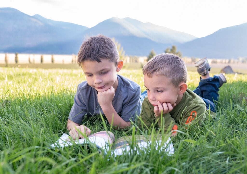 seasons activity books -kids reading a book in the grass